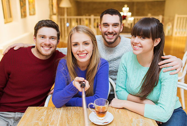 Photo Printing - Selfie Stick - Group of friends at dinner taking a selfie